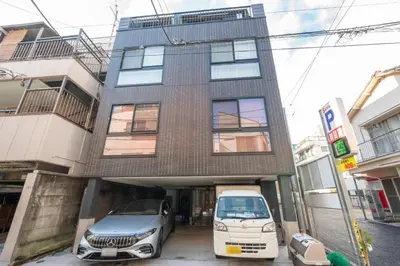 a building with two cars parked in front of it at Hit\u9326\u7cf8\u753a in Tokyo