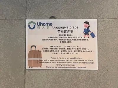 a sign on a wall with a suitcase on it at Uhome Fabric Hotel in Tokyo