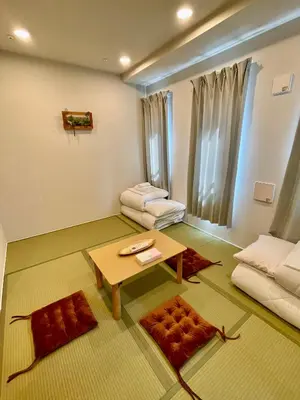 a living room with a table and a couch at Uhome Fabric Hotel in Tokyo