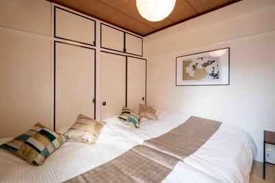 a bedroom with a large white bed with pillows at FIKA Asakusa in Tokyo