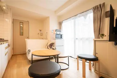a kitchen with a table and two stools in a room at FIKA Asakusa in Tokyo