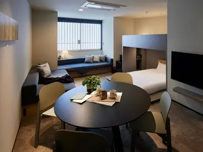 a hotel room with a table and a bedroom at Minn Nihonbashi Suitengumae in Tokyo