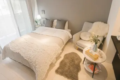 a bedroom with a white bed and a couch at Roppongi Designer Apartment Newly built 5 minutes walk to the station in Tokyo