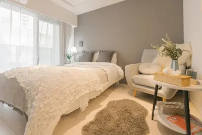 a bedroom with a bed and a couch and a chair at Roppongi Designer Apartment Newly built 5 minutes walk to the station in Tokyo