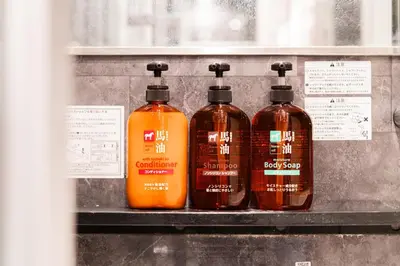 three bottles of soap sitting on a shelf at Roppongi Designer Apartment Newly built 5 minutes walk to the station in Tokyo