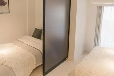 a mirror in the corner of a room with a bed at Roppongi Designer Apartment Newly built 5 minutes walk to the station in Tokyo