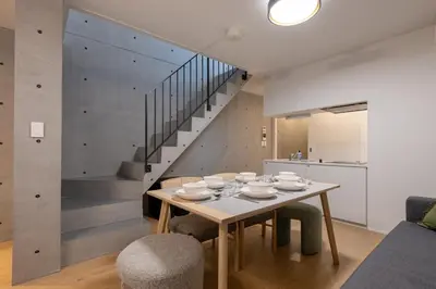 a dining room with a table and a staircase at TOKYO SHIBA Retreat 3427 in Tokyo
