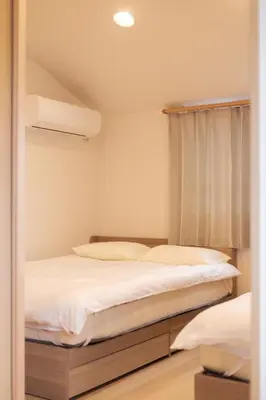 a bedroom with two beds and a window at Miyabi Inn-Higashi Koiwa in Tokyo