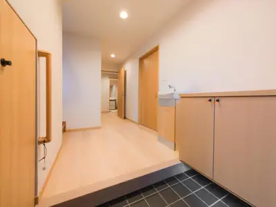 a hallway of an apartment with wooden cabinets and a kitchen at Miyabi Inn-Higashi Koiwa in Tokyo