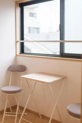 a table and two stools in front of a window at Miyabi Inn-Higashi Koiwa in Tokyo