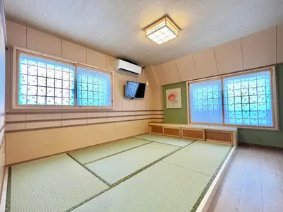 a large empty room with windows and a tv at \u4e0a\u91ce\u65e5\u5f0f\u6c11\u5bbf in Tokyo