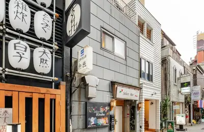 a building with a clock on the side of it at \u4e0a\u91ce\u65e5\u5f0f\u6c11\u5bbf in Tokyo