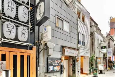 a building with clocks on the side of it at \u4e0a\u91ce\u65e5\u5f0f\u6c11\u5bbf in Tokyo