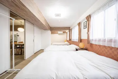 a bedroom with two beds and a dining room at Vacation Inn Omorikaigan in Tokyo