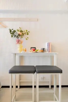 a table with two stools in front of a table at Felizstay Tokyo in Tokyo