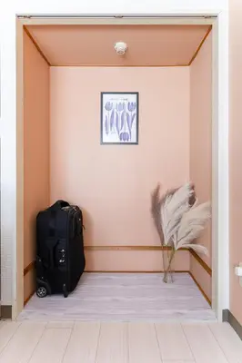 a suitcase sitting in the corner of a room at Felizstay Tokyo in Tokyo