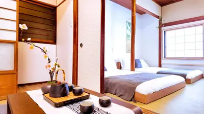 a bedroom with two beds and a desk and a table at 9Stay\u897f\u6d45\u8349 in Tokyo