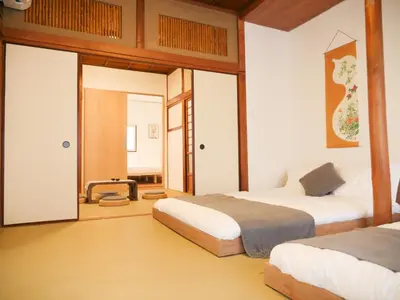 a bedroom with two beds and a door to a room at 9Stay\u897f\u6d45\u8349 in Tokyo