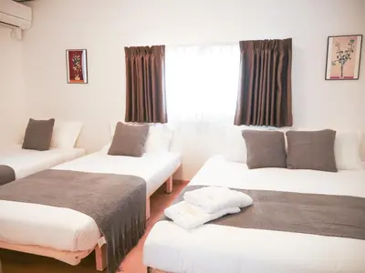 a room with three beds and a window at 9Stay\u897f\u6d45\u8349 in Tokyo