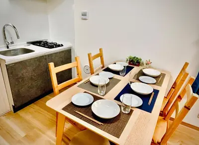 a wooden table with plates and bowls on it in a kitchen at \u62bc\u4e0a\u30d6\u30ea\u30b9\u30cf\u30a6\u30b9 in Tokyo