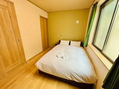 a bedroom with a bed in a room with a window at \u62bc\u4e0a\u30d6\u30ea\u30b9\u30cf\u30a6\u30b9 in Tokyo