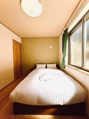 a large bed in a room with a window at \u62bc\u4e0a\u30d6\u30ea\u30b9\u30cf\u30a6\u30b9 in Tokyo