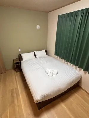 a bedroom with a bed with two towels on it at \u62bc\u4e0a\u30d6\u30ea\u30b9\u30cf\u30a6\u30b9 in Tokyo