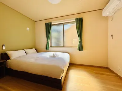 a bedroom with a large bed with a window at \u62bc\u4e0a\u30d6\u30ea\u30b9\u30cf\u30a6\u30b9 in Tokyo