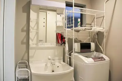 a bathroom with a sink and a toilet and a mirror at Sensoji 2ppl Apt in Tokyo