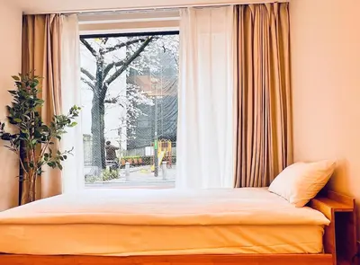 a bed in a room with a window at \u65b0\u4e0a\u53cc\u5367\u5957\u623f \u6700\u59275\u4eba \u8bbe\u8ba1\u5e08\u98ce\u683cYaof \u4e1c\u4eac\u4e2d\u5fc3\u4e0a\u91ce\u516c\u56ed3\u5206\u949f \u8f66\u7ad91\u5206\u949f \u4f4d\u7f6e\u6781\u4f73\u8d85\u7ea7\u7e41\u534e \u623f\u95f4\u5185\u770b\u6a31\u82b1 in Tokyo