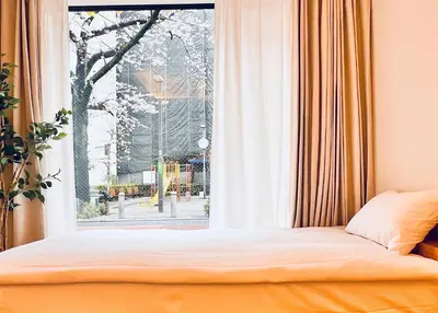 a bedroom with a bed and a large window at \u65b0\u4e0a\u53cc\u5367\u5957\u623f \u6700\u59275\u4eba \u8bbe\u8ba1\u5e08\u98ce\u683cYaof \u4e1c\u4eac\u4e2d\u5fc3\u4e0a\u91ce\u516c\u56ed3\u5206\u949f \u8f66\u7ad91\u5206\u949f \u4f4d\u7f6e\u6781\u4f73\u8d85\u7ea7\u7e41\u534e \u623f\u95f4\u5185\u770b\u6a31\u82b1 in Tokyo