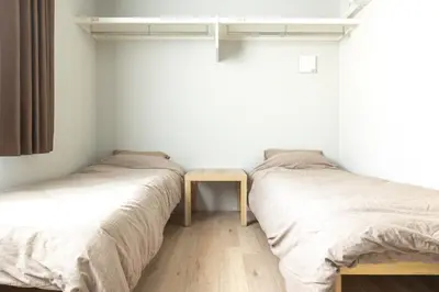 two beds in a room with a table between them at Marvelous Higashikanda - Vacation STAY 88263v in Tokyo