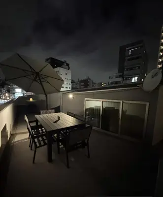 a table and chairs on a balcony at night at Hotel Alphinaud - Vacation STAY 91089v in Tokyo