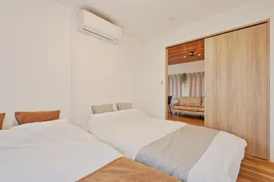 two white beds in a room with a couch at V Close to Shinjuku Kabukicho Korean Town FrWIFI L in Tokyo