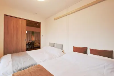 two white beds in a room with a table at V Close to Shinjuku Kabukicho Korean Town FrWIFI L in Tokyo