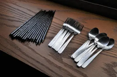 a group of forks and spoons on a wooden table at \u539f\u7530\u5c4bHotel 3F in Tokyo