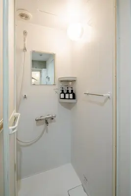 a white bathroom with a shower and a mirror at \u539f\u7530\u5c4bHotel 3F in Tokyo