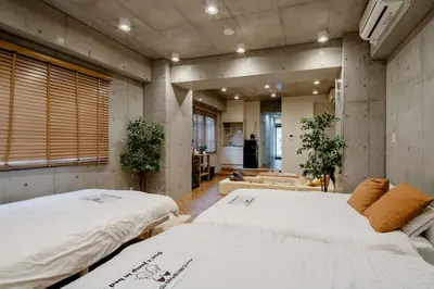 a room with two beds and a living room at \u539f\u7530\u5c4bHotel 3F in Tokyo