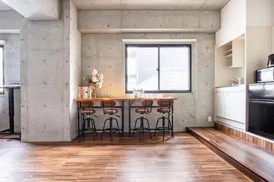 an industrial kitchen with a bar with stools at \u539f\u7530\u5c4bHotel 4F in Tokyo