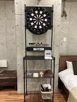 a dart board on a wall next to a bed at \u539f\u7530\u5c4bHotel 4F in Tokyo
