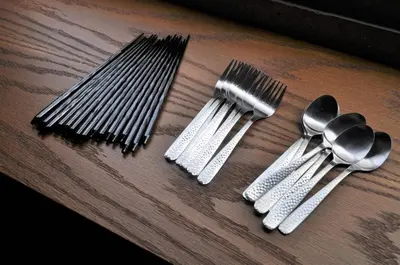 a group of forks and spoons on a wooden table at \u539f\u7530\u5c4bHotel 4F in Tokyo