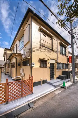 a yellow building with a fence in front of it at Fullhouse 101 in Tokyo