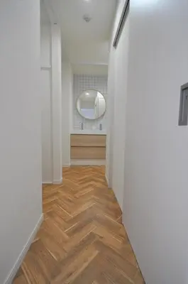 a hallway with white walls and wooden floors and a mirror at Fullhouse 101 in Tokyo