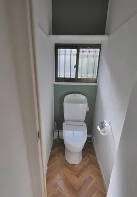 a small bathroom with a toilet with a window at Fullhouse 101 in Tokyo