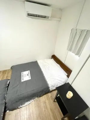 a small bedroom with a bed and a table at Fullhouse 101 in Tokyo