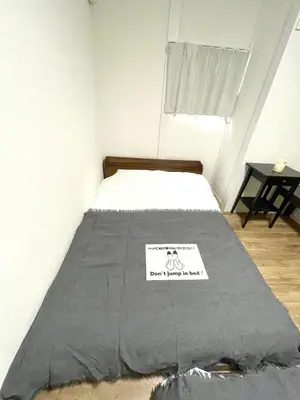 a bed in a room with a sign on it at Fullhouse 101 in Tokyo