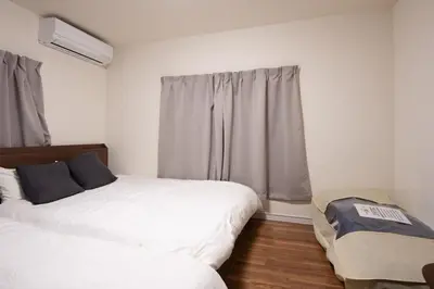 a bedroom with two beds and a window at Fullhouse 102 in Tokyo