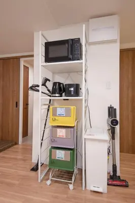 a room with a shelf with a microwave on it at Fullhouse 201 in Tokyo