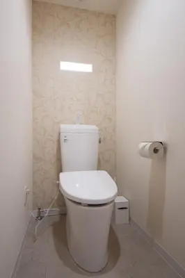 a white toilet in a bathroom with a roll of toilet paper at Fullhouse 201 in Tokyo