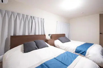 a bedroom with two beds and a window at Fullhouse 202 in Tokyo
